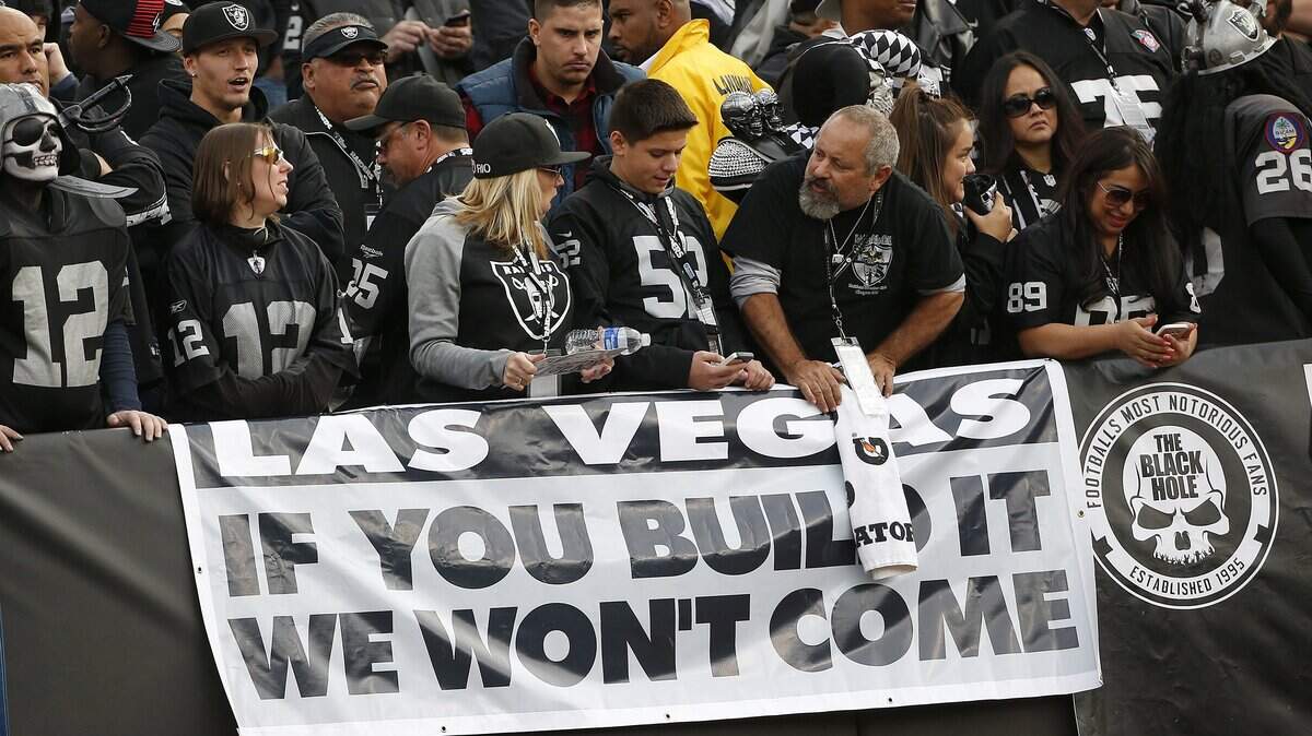 Raiders fans hold up a sign about the team’s move to Las Vegas, then only a possibility, during a game against the Carolina Panthers in Oakland on Nov. 27, 2016.