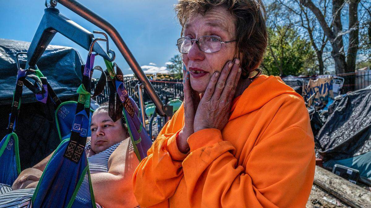 Sharon Jones, a leader of Camp Resolution, tears up alongside Holly Porter, left, who was hanging in a sling while waiting on a representative from a property management company on Friday, March 24, 2023. Jones and her partner Joyce Williams have been instrumental in trying to get Porter housing, along with several other residents of the self-governing homeless camp in North Sacramento.