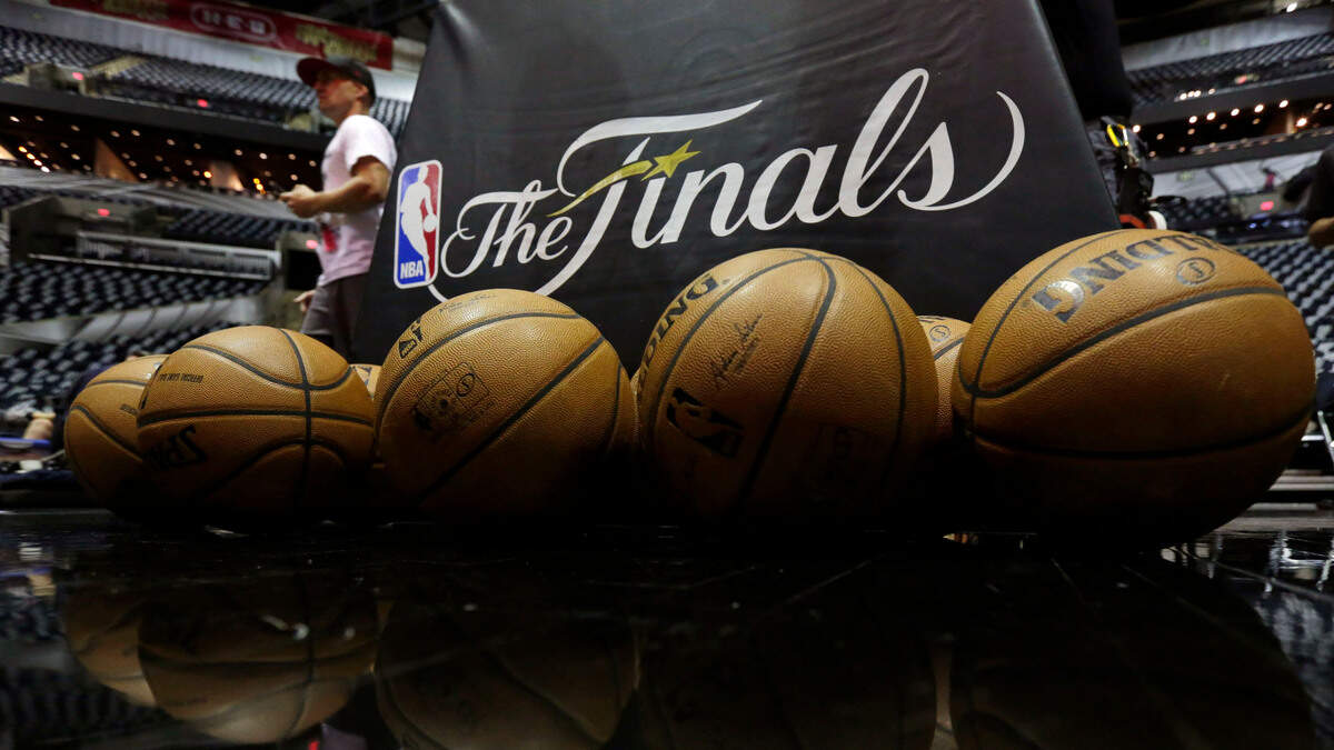 NBA basketballs and the NBA Finals logo are seen on the court prior to Game 1 of the NBA Finals basketball series between the San Antonio Spurs and Miami Heat, Thursday, June 5, 2014, in San Antonio. (AP Photo/Eric Gay)
