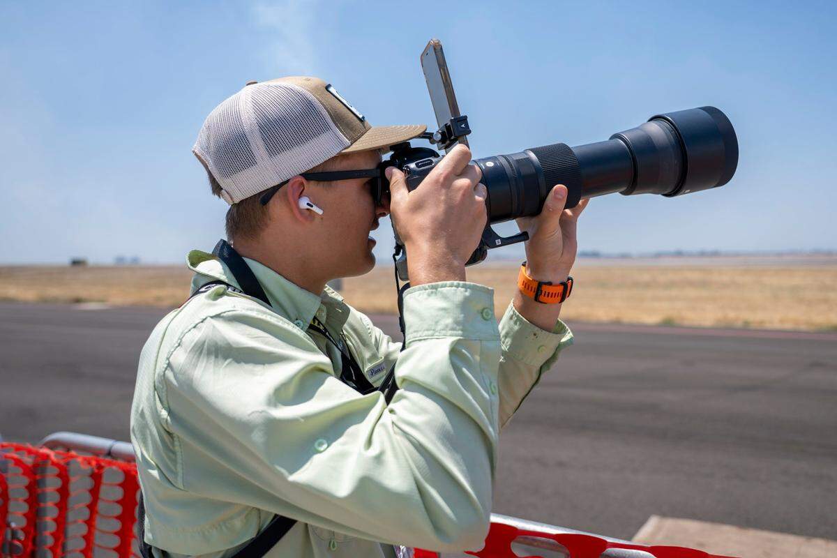 Zachary Tull aims his camera while recording on his iPhone and listening to radio traffic through a headphone during the Air & Space Expo at Beale Air Force Base on Saturday.