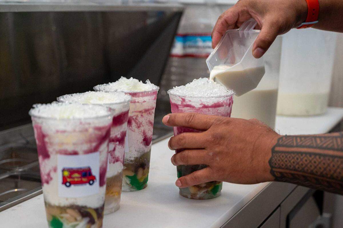 Co-owner Ray Suavillo makes halo-halo by pouring cream into shaved ice and toppings at Spoon and Fork in Sacramento on Thursday.