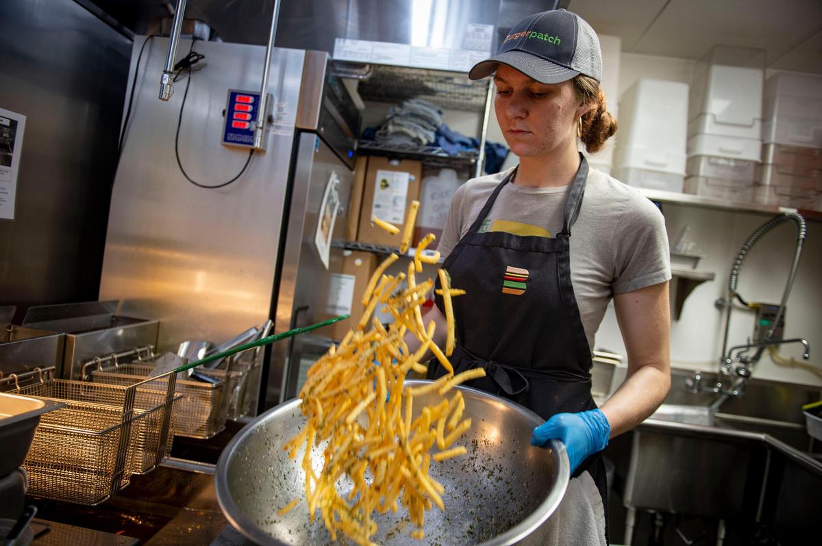 Chef Kayla Murray seasons french fries Thursday, Nov. 14, 2019, at Burger Patch restaurant in midtown, where the co-owner Danea Horn has started an organization called Gril Power, to heighten awareness of women working in kitchens.