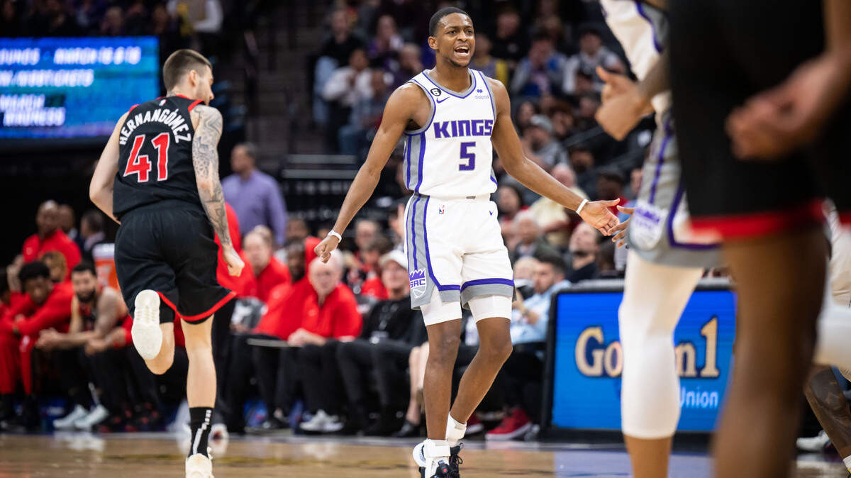Sacramento Kings guard De’Aaron Fox (5) reacts after scoring a three point basket during the second quarter, as Toronto Raptors forward Juancho Hernangomez (41) prepares on offense at left, at the NBA basketball game Wednesday, Jan. 25, 2023, at Golden 1 Center in Sacramento.