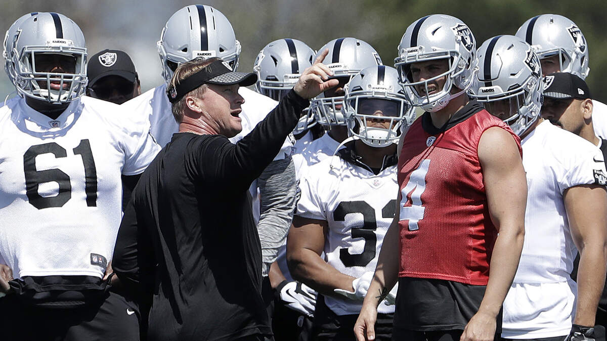 Raiders coach Jon Gruden, center left, talks with quarterback Derek Carr (4) and offensive players at the team facility in Alameda on April 24.