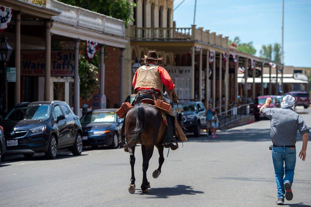Steve Pool rides off on his Arabian horse “Guy” on the first leg of the Pony Express Trail re-ride, Wednesday, June 16, from Old Sacramento as a fan runs alongside. More than 750 riders are expected to take part in the event, handing off letters across 1,966 miles to St. Joseph, Missouri, in 10 days or less.
