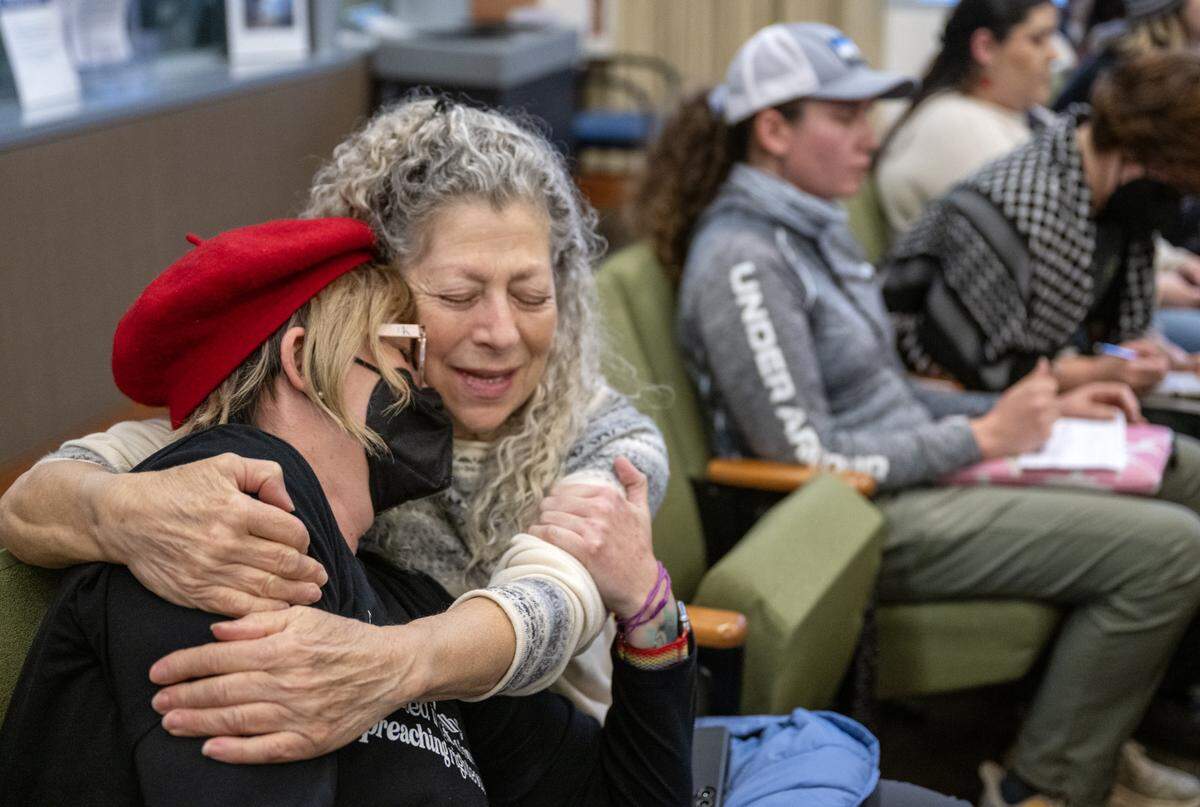 Sacramento resident Randi Gottlieb embraces her friend Stacy Givens, left, after Givens spoke during the Sacramento City Council meeting on Tuesday.