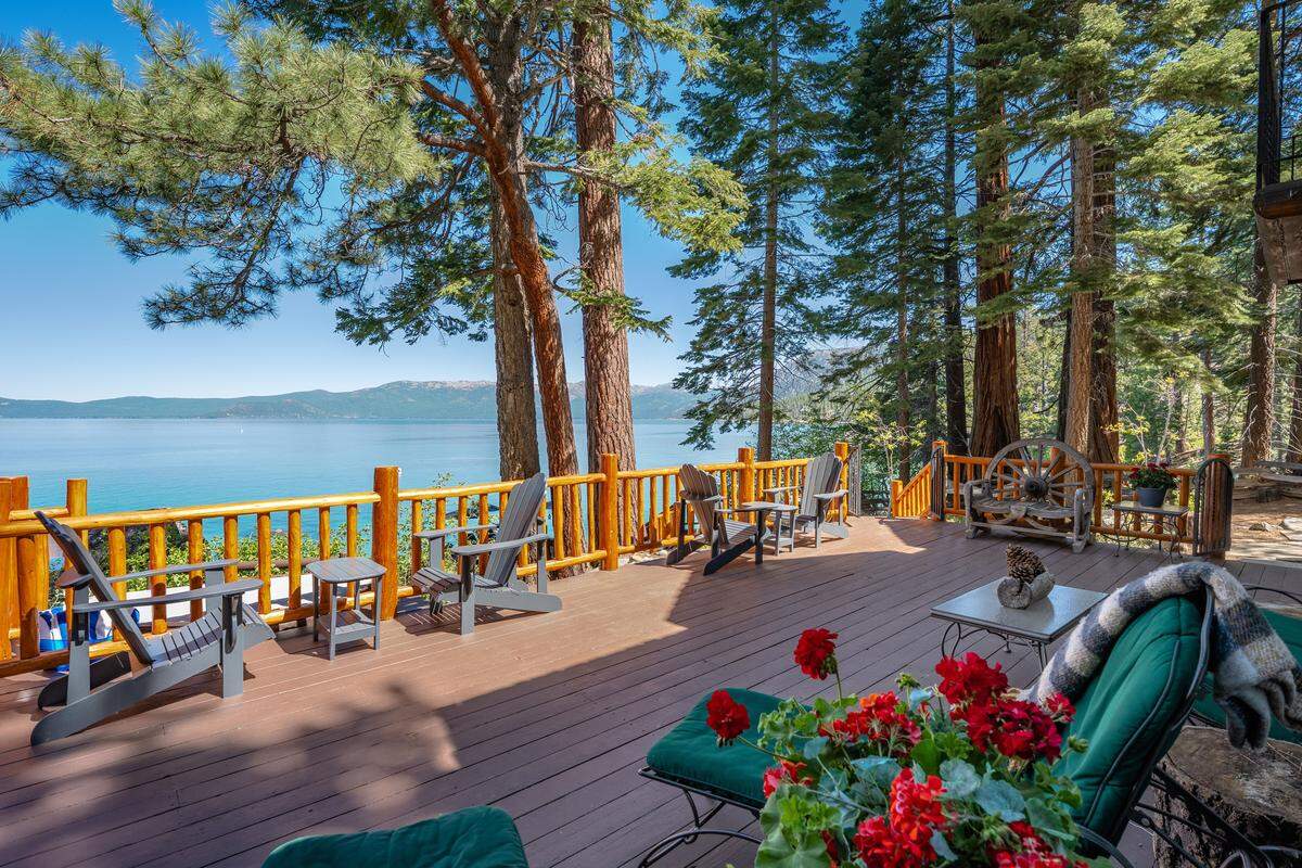 The main residence has three bedrooms and three full bathrooms, with living spaces oriented toward panoramic views across the lake.