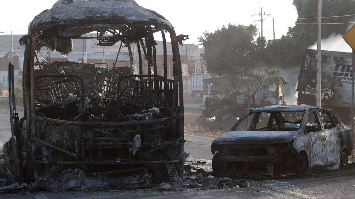 A view of a burned bus and car, allegedly set on fire by organized crime groups in response to an operation to arrest a high-priority security target, on a highway near Acatlan de Juarez, Jalisco state, Mexico taken on Feb. 22, 2026. The Mexican army announced that it had killed powerful drug lord Nemesio "El Mencho" Oseguera in an operation that sparked a wave of violence in various parts of the country on Feb. 22.  (Ulises Ruiz/AFP via Getty Images/TNS)