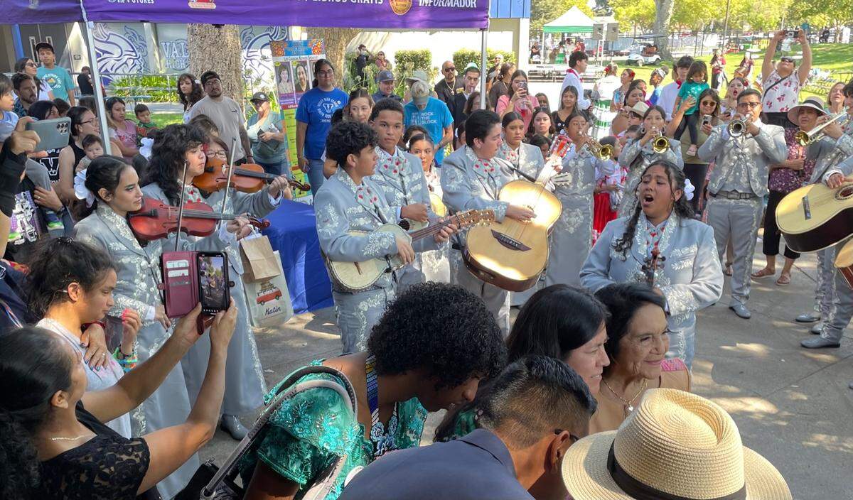 Members of Woodland musical group Mariachi Los Claveles perform Saturday at the Sacramento Latino Book & Family Festival at Valley High School as festival guest of honor, civil rights leader Dolores Huerta, lower right, poses for a photo.