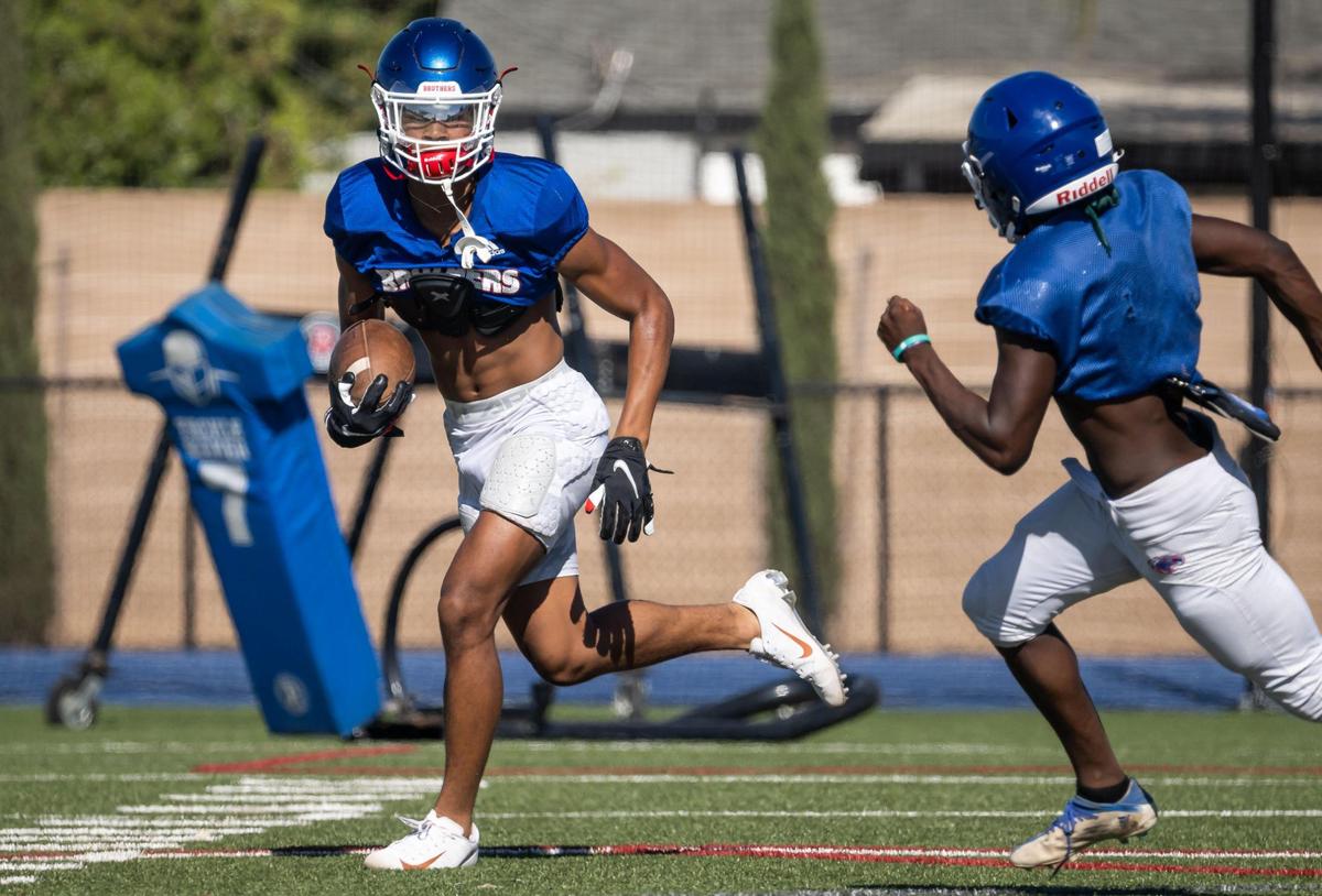 Phillip Bell, only a sophomore and already a standout wide receiver for Christian Brothers High School, runs back a punt as teammate Daniel Kamara approaches during a varsity football practice Thursday, Aug. 11, 2022, at the school in Sacramento.