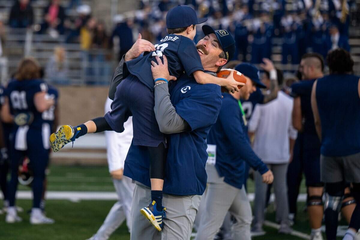 UC Davis Aggies head coach Tim Plough embraces his son Jackson following the victory over the Illinois State Redbirds in the FCS playoffs second-round game Saturday at UC Davis Health Stadium in Davis.