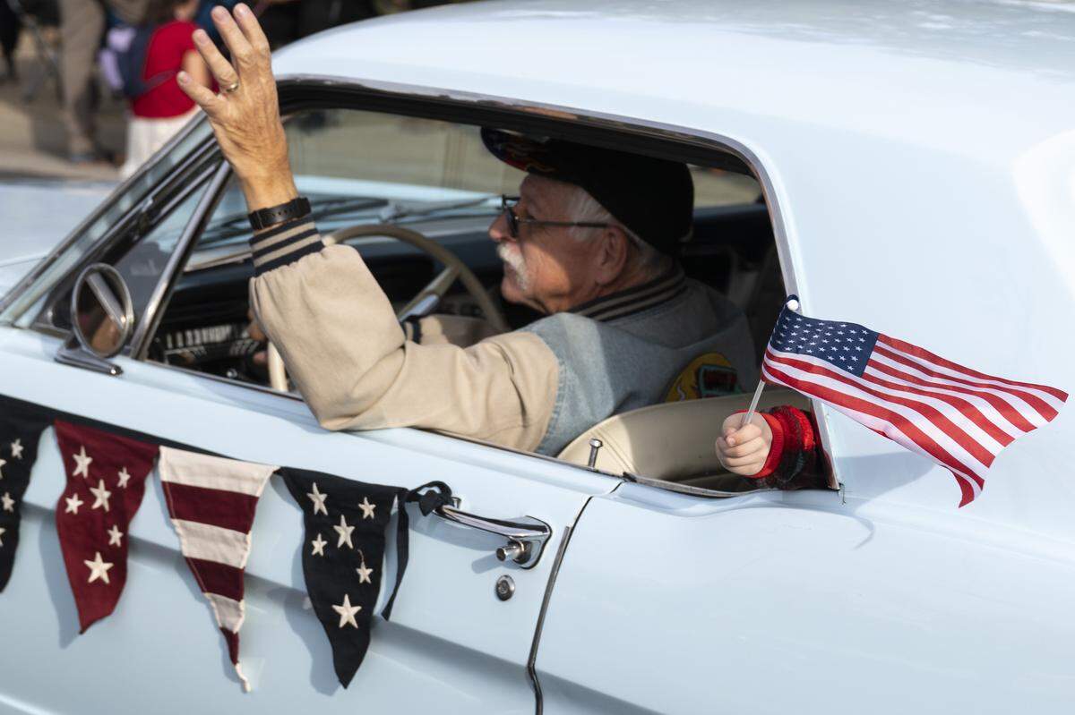Vintage cars are driven down East Bidwell Street during a Veterans Day parade in Folsom on Tuesday, Nov. 11, 2025.