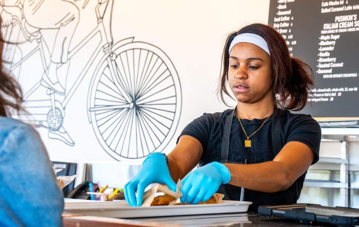 An employee at Pushkin’s Bakery & Cafe helps a customer with an order of pastries at the company’s new location in Arden Arcade on Monday.