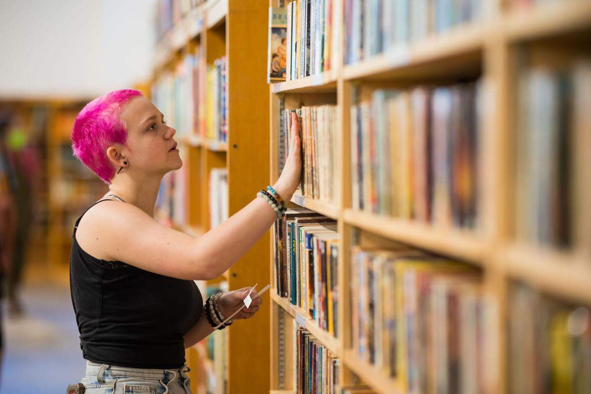 Charlie Stadem, 17, of Sacramento, works on categorizing and organizing at Beers Books during their soft opening Saturday, Aug. 26, 2023, at 712 R St. in Sacramento. They said they began working at the bookstore during a high school internship, and is now on staff at the decades-old business.