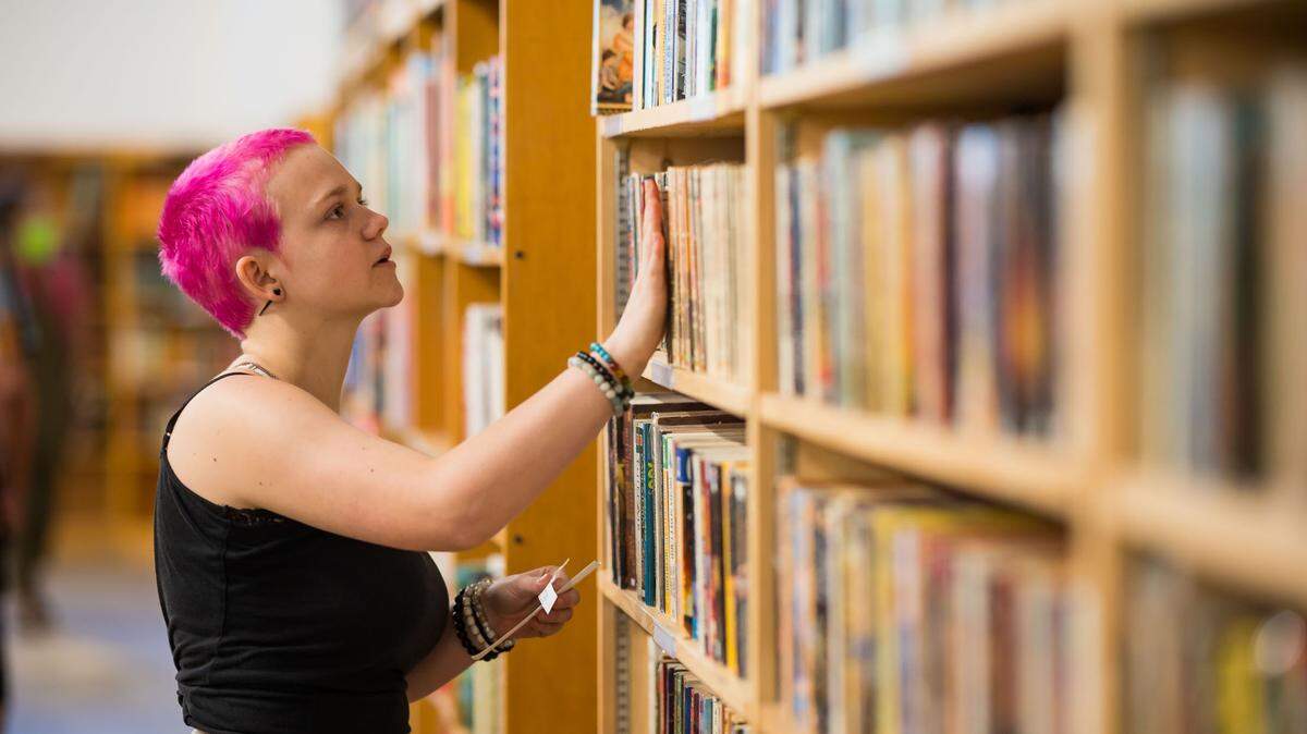 Charlie Stadem, 17, works on categorizing and organizing at Beers Books during their soft opening on Aug. 26 in Sacramento. She said she began working at the book store during a high school internship, and is now on staff at the decades-old business.