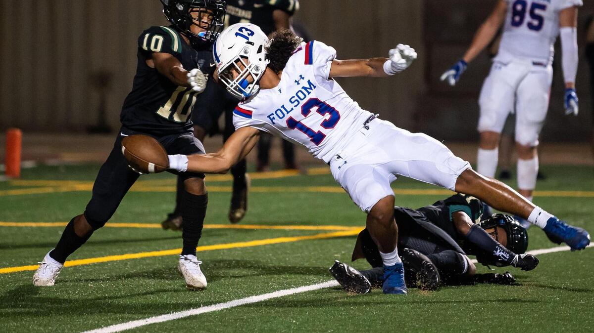 Folsom wide receiver Rico Flores Jr. reaches into the end zone to score on a pass from Tyler Tremain in the second quarter as Monterey Trail’s Arik Phillips, left, and Mizay Davis defend during the nonleague high school football game Friday, Aug. 20, 2021, at Monterey Trail High School in Elk Grove.