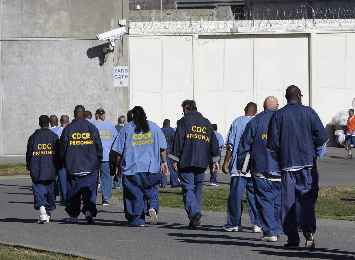 Inmates walk through the exercise yard at Folsom State Prison in 2013. Proposition 57 gave some inmates early parole opportunities and more chances to shave down their sentences through credit-earning.
