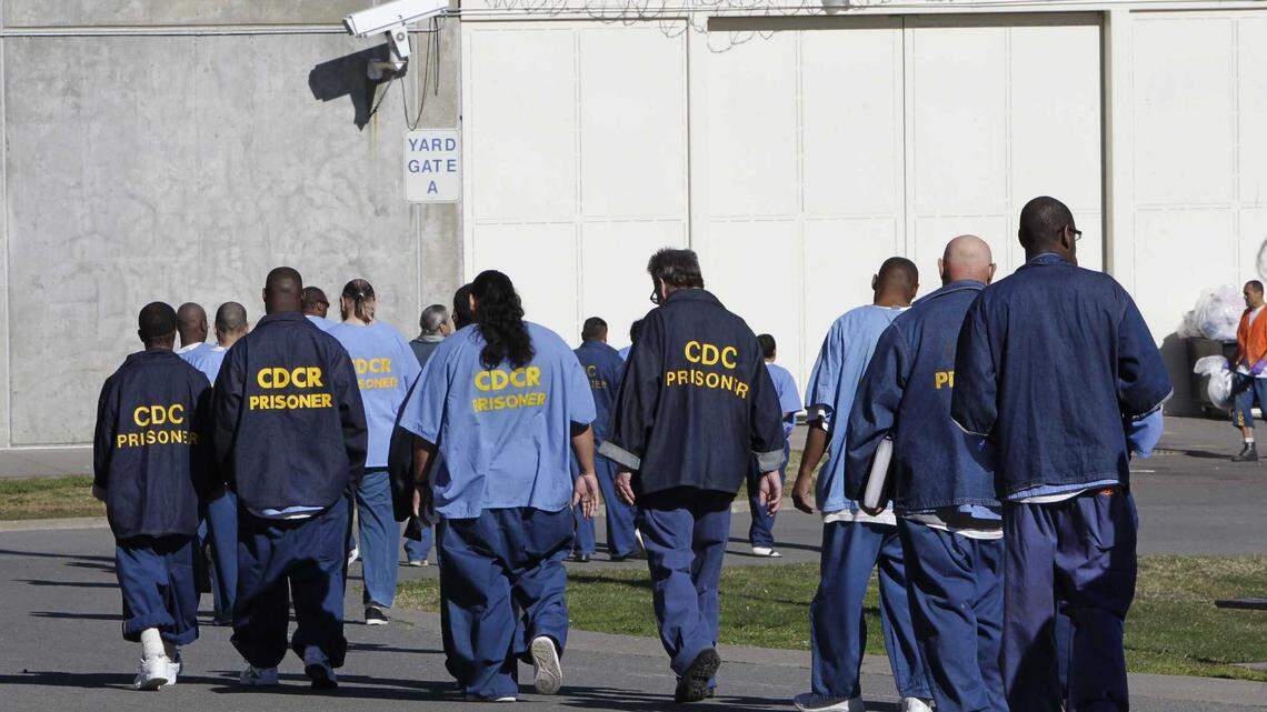Inmates walk through the exercise yard at California State Prison, Sacramento, near Folsom in 2013. A group of California district attorneys sued the state corrections department seeking a halt to new good conduct credit rules they claim will result in early release of 76,000 prison inmates.