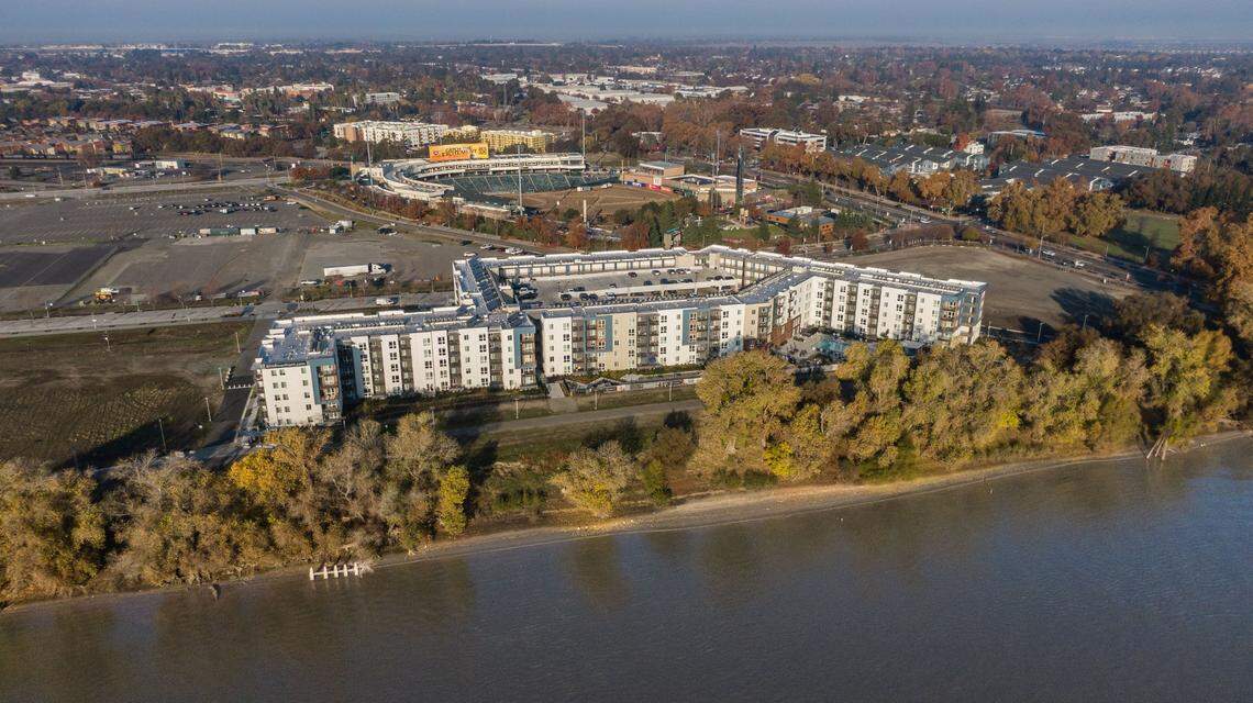 The recently opened 805 Riverfront apartments, photographed by drone on Friday, Dec. 6, 2024, stand between the Sutter Health ballpark and the Sacramento River in West Sacramento.