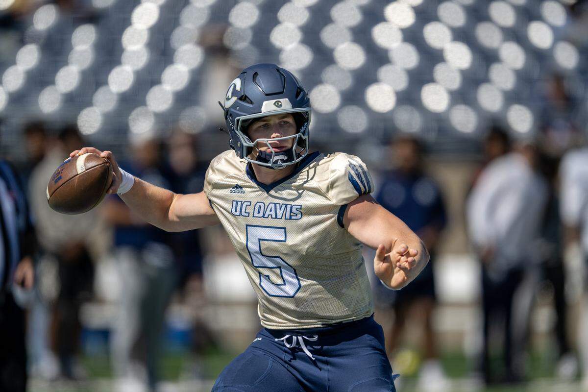 UC Davis quarterback Treynor Cleeland rolls out to pass during spring practice at UC Davis Health Stadium on April 18.