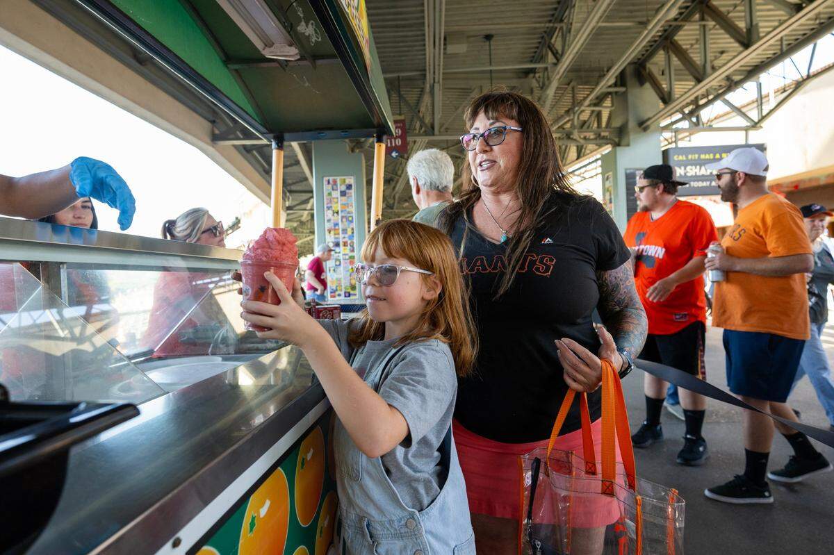 Shelly Neeley of Fair Oaks watches as Lillian Reed, 10, gets her first-ever Merlino’s ice freeze on June 21 at Sutter Health Park in West Sacramento.