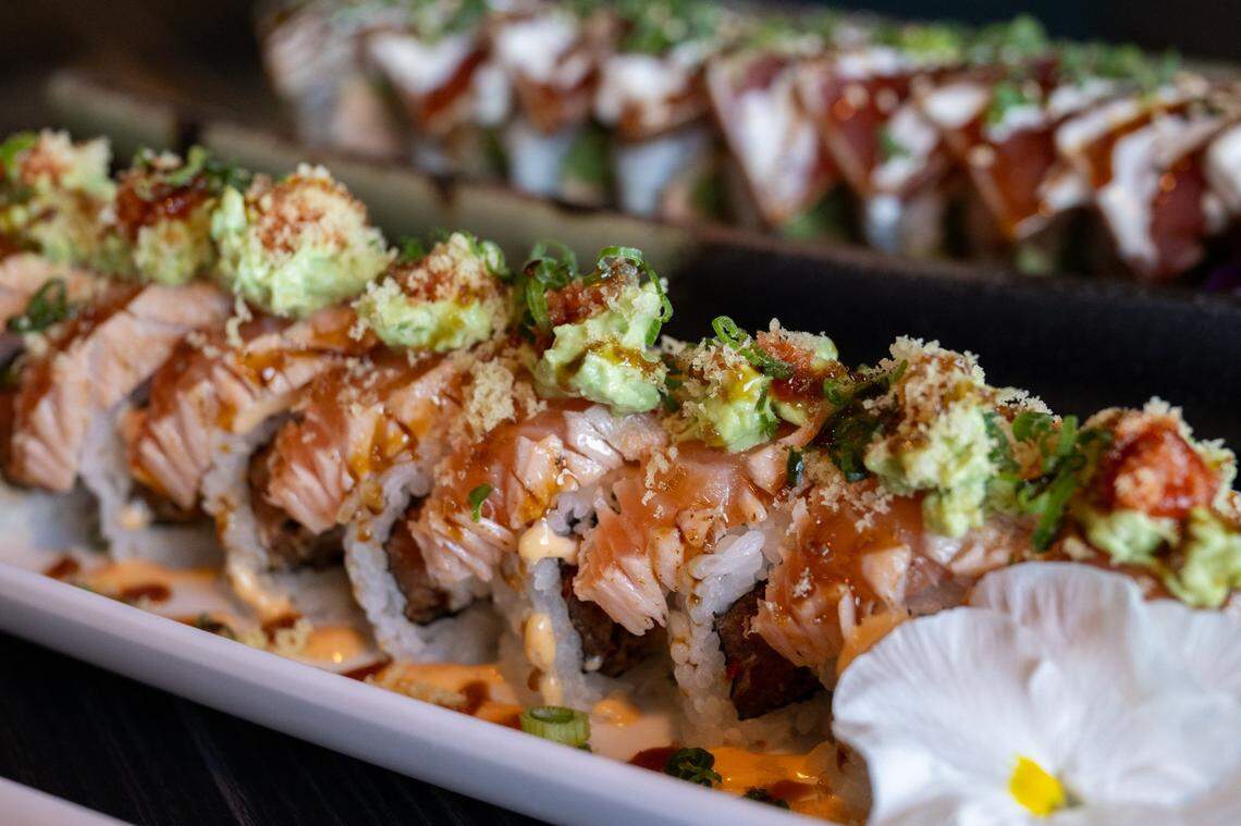 The ugzilla roll made with tempura softshell crab, spicy tuna, jalapenos, tempura flakes, seared salmon steak slices, scallion, masago, a house special avocado mixture, unagi and sriracha at Makisu Sushi.