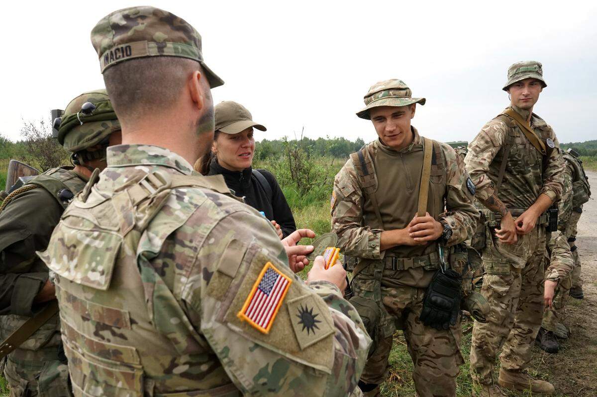 California National Guard Soldier Master Sgt. Manuel E. Inacio listens as a translator explains the meaning of a patch he received from a member of the Ukrainian military in Yavoriv, Ukraine, in 2018. Trading patches is a common tradition between troops from partnering nations during training exercises.