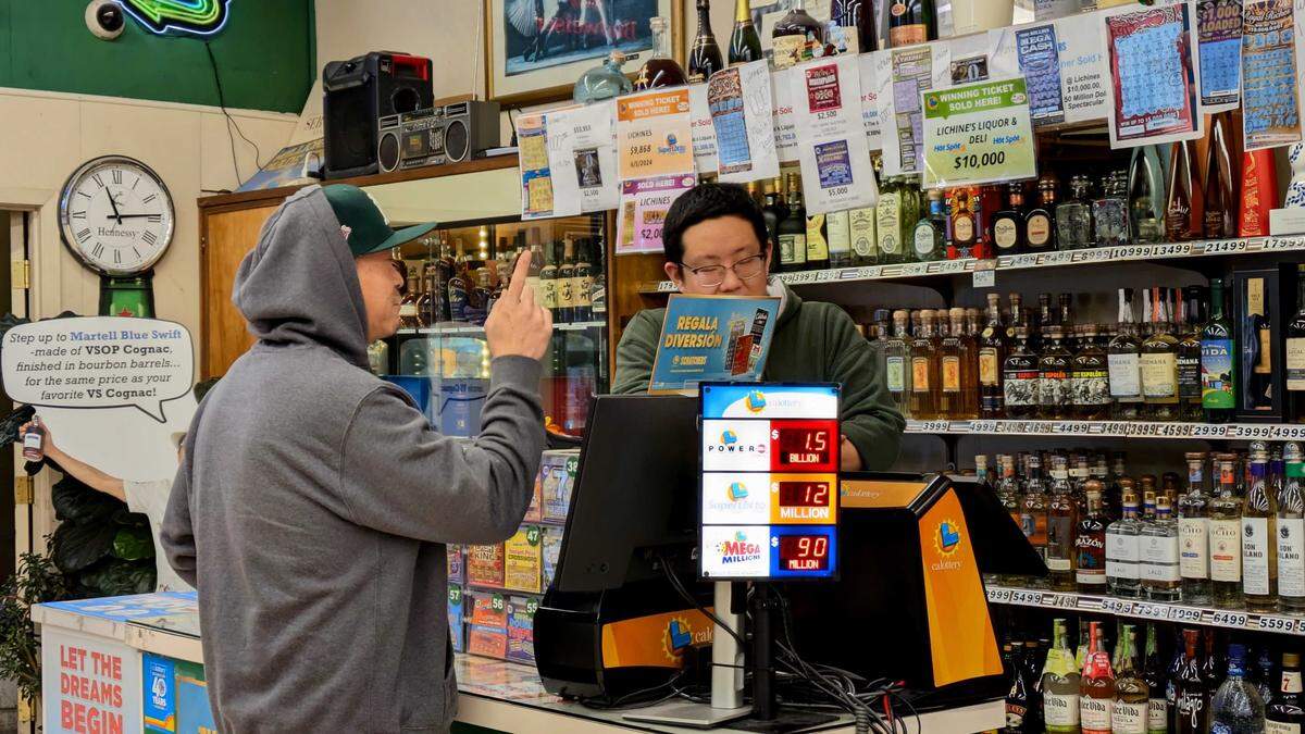 Saan Saephan purchases his Powerball ticket at Lichine’s Liquor & Deli on Friday, Dec. 19, 2025. He said he’s come to the store twice in the last week because “it’s a lucky store.”