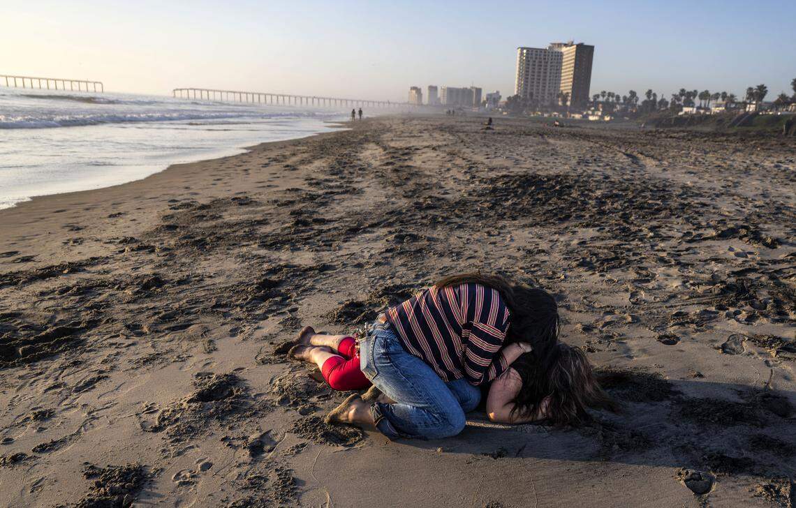 Maria de Jesus Estrada, una beneficiaria de DACA que fue deportada en febrero a México, se derrumba en la playa mientras es consolada por Ivonne Rodriguez, directora de prensa que trabaja en reforma migratoria en FWD.US, en Rosarito, México, el domingo 29 de marzo de 2026. Estrada espera regresar a Sacramento después de que un tribunal federal ordenara su retorno.