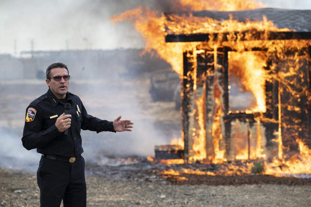 Frank Bigelow, deputy director of Cal Fire’s Office of the State Fire Marshal, speaks during a burn demonstration at the Sacramento City Fire Training Facility at McClellan Airfield on Wednesday. Cal Fire and IBHS hosted the burn to demonstrate the impact of proposed Zone Zero regulations in a wild fire scenario.
