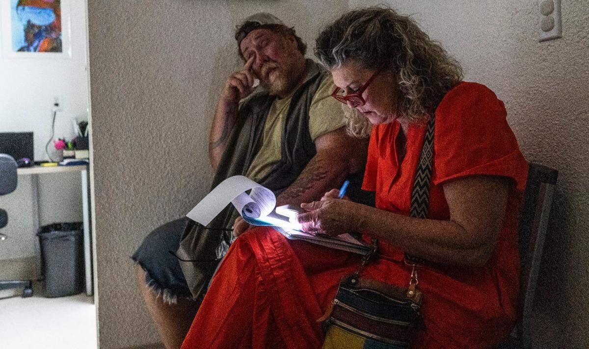 Maria Montano, a social worker at the Sacramento Public Library, helps Paul Jackson fill out paper work at an optometry appointment on June 10.