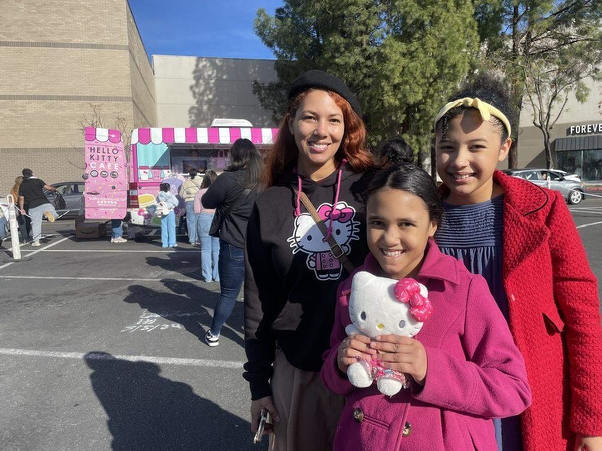 Elly Ellis, left, with her two daughters Harley, middle, and Aubrie, wait in line for the Hello Kitty Cafe pop-up in Sacramento on Saturday.