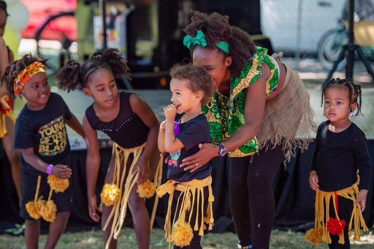 Nakia Porter, Melanin Day School Academy director, tries to get the younger children to bow after their performance at the 2022 Sacramento Banana Festival at William Land Park.