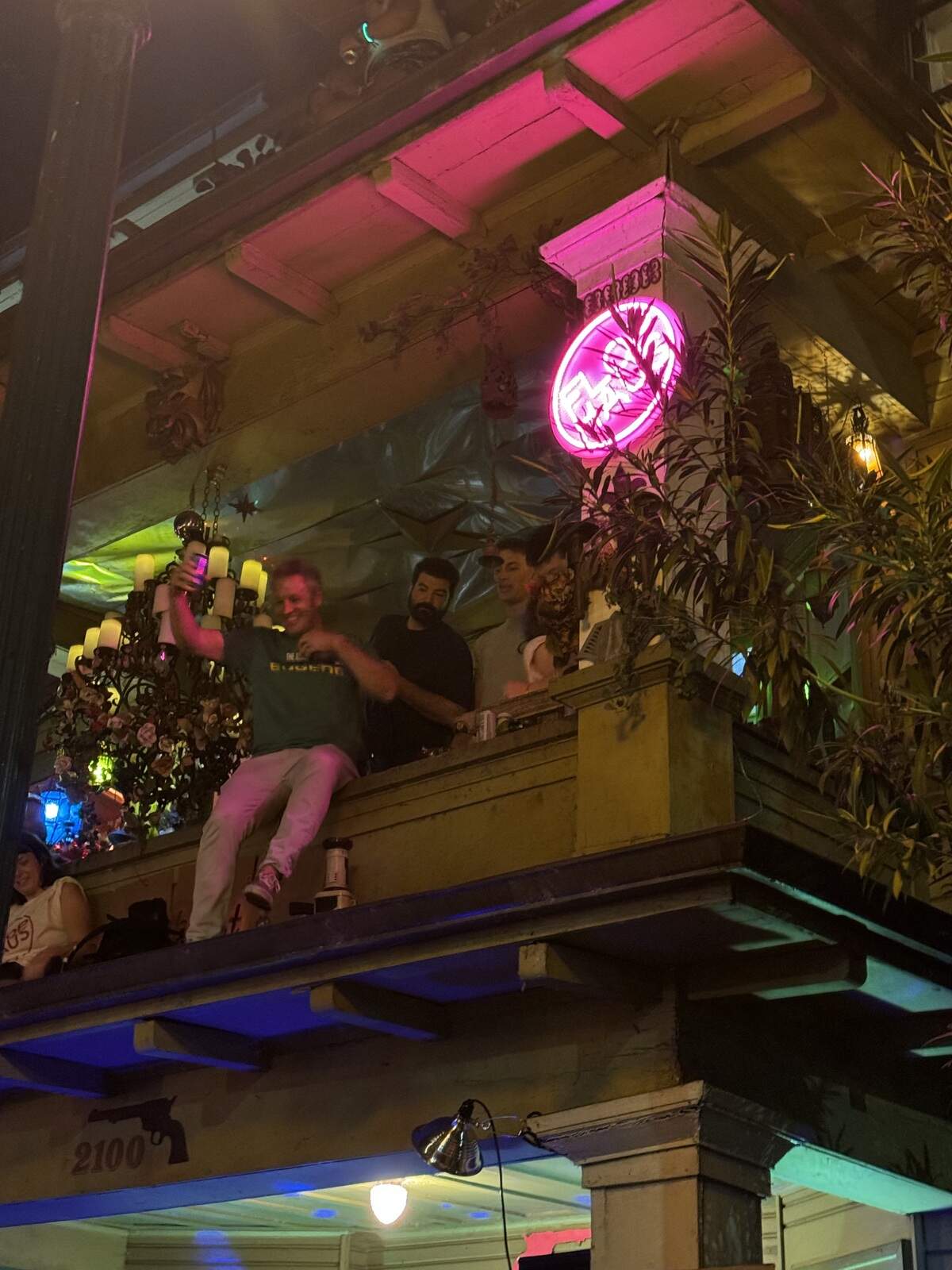 A reveler toasts to the crowd from the roof of the Flop Haus, at the corner of 21st and I streets in Midtown Sacramento, during Sac Porchfest in 2024.