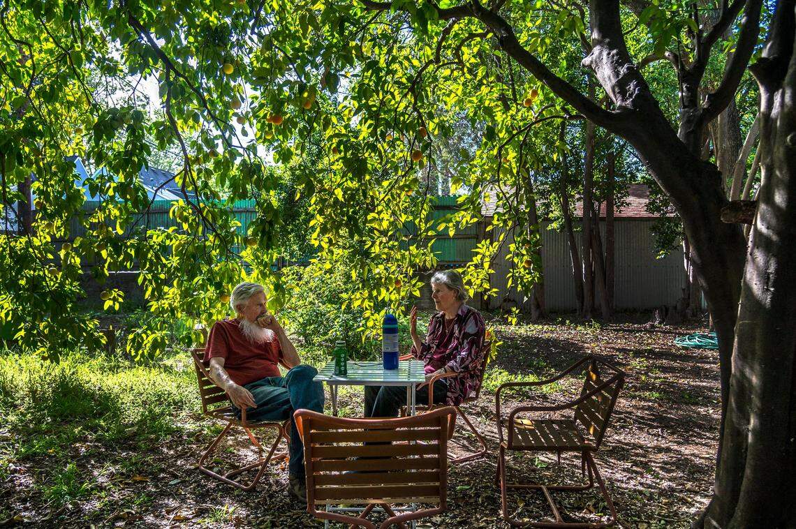 Dan Altstatt left, who is facing $573,000 in fees from the city for code violations, discusses his situation with his friend Kim Glazzard in his East Sacramento backyard on Thursday, beneath his orange and grapefruit trees. “I think the whole code enforcement thing needs to be revisited and revamped. They need to consider the people they are dealing with and their issues,” said Altstatt.