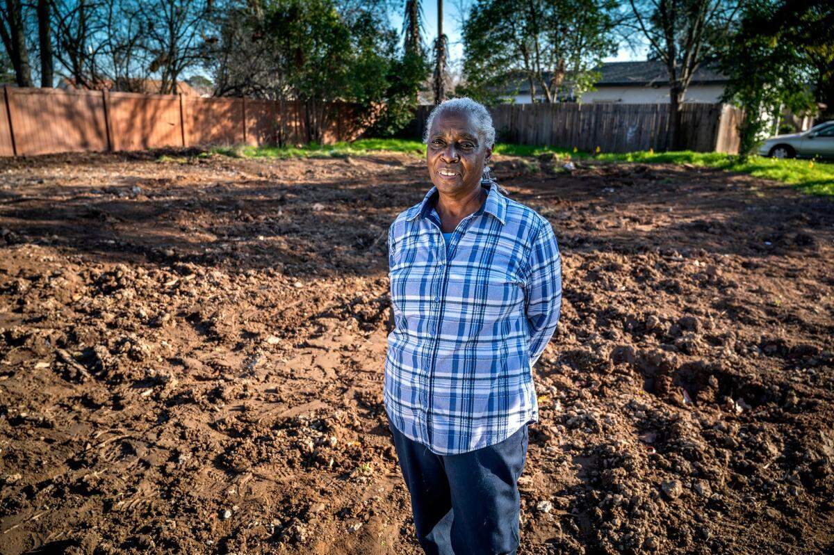 Wanda Clark stands in the vacant lot where her house once stood on Wednesday. As a result of activists intervening, the city agreed to negotiate a new deal for her. Her house was demolished but she could keep the land, and the $100,000 in receivership fees are being waived. “My grandkids have nowhere to come see their Nana,” said Clark.