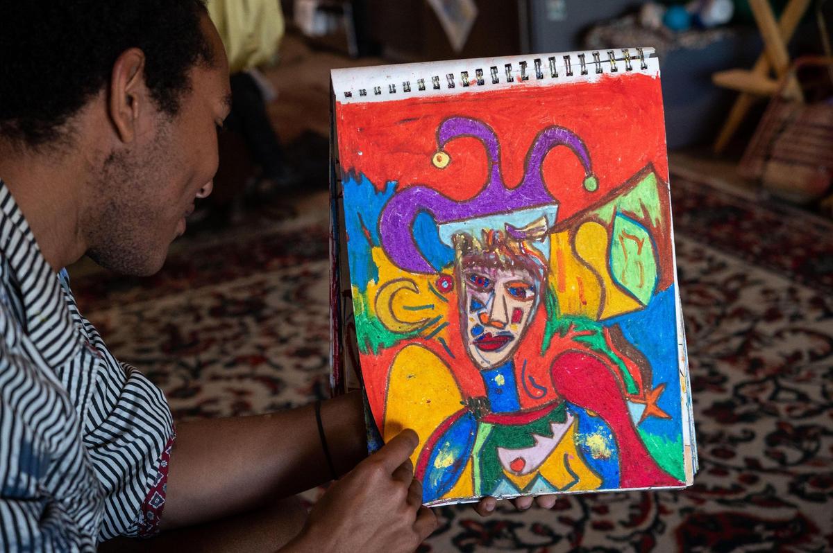 Artist Halcyon Clay thumbs through a book of drawings and pastels he recently filled up, stopping to describe some of his work, during an interview Thursday, Feb. 4, 2021, at a loft in the the WAL building in midtown Sacramento.