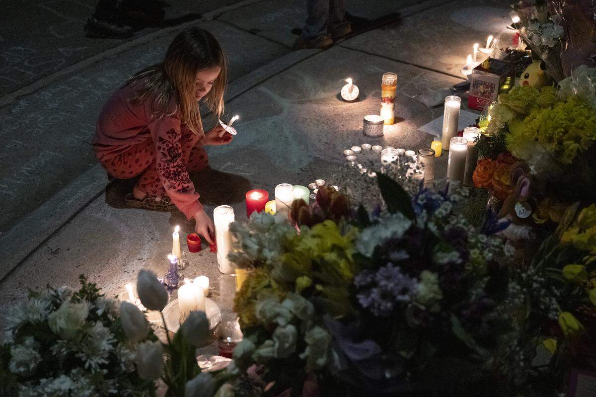 Neighbors light candles during a vigil on Mill Water Circle in Rancho Cordova on Sunday to remember the Vallerga family who were found dead in their home on the street on Jan. 27 in an apparent murder-suicide.
