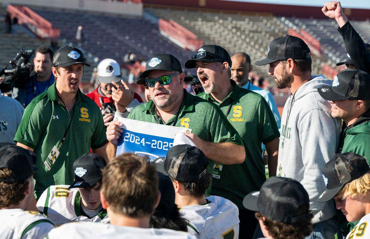 Sonora coach Kirk Clifton holds up the the Sac-Joaquin Section Division VI championship banner after his team defeated the Bradshaw Christian Pride at Hughes Stadium in Sacramento on Friday, Nov. 29, 2024.