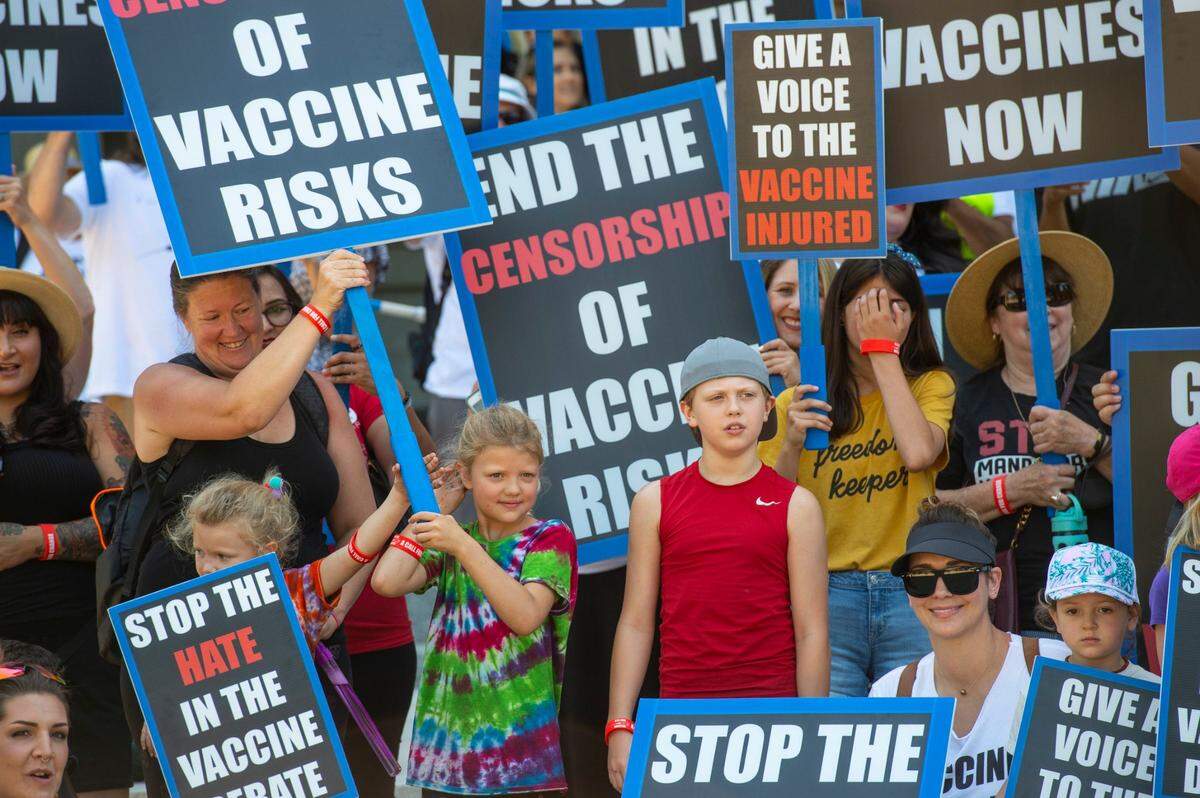 Myriah Husak, 8, and her brother Nicholas, 10, stand among the crowd at the V is for Vaccine organized demonstration on Tuesday, June 23, 2020. No masks were observed at the protest.
