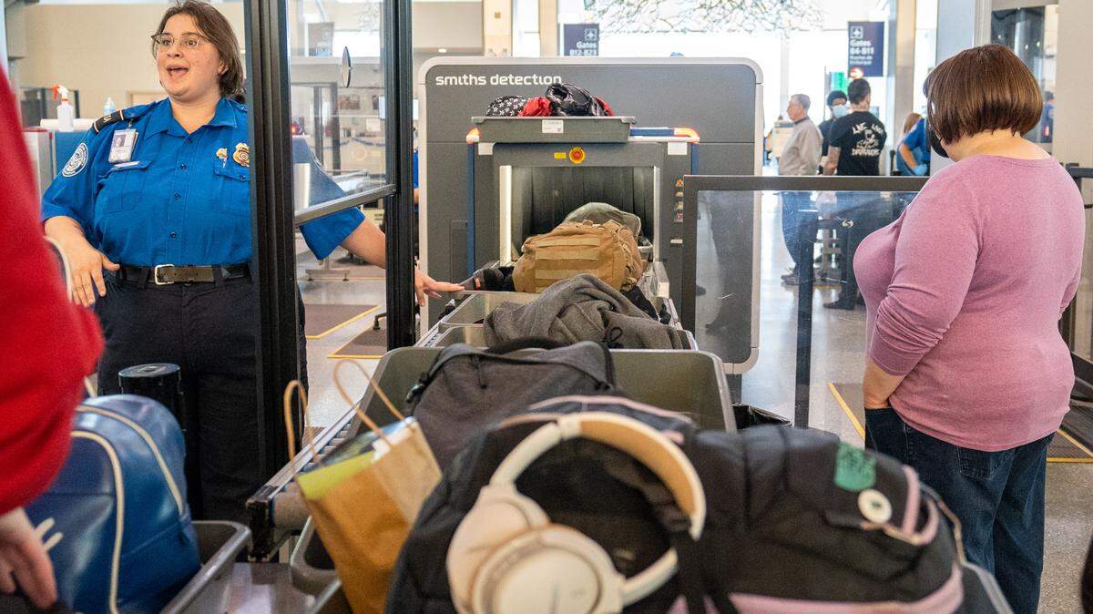 A Sacramento International Airport Terminal B TSA officer directs passengers through security on Dec. 20, 2022.