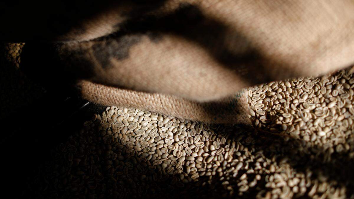 Coffee beans rest in a bin as Tony Tausch, owner of Coffee Emporium, works in his coffee roasting space, Friday, Jan. 26, 2018, in the Over-the-Rhine neighborhood of Cincinnati. Small business operators like Tausch have helped usher in a neighborhood renaissance through community engagement and entrepreneurship, developing once abandoned storefronts and attracting new residents in the struggling downtown area. (AP Photo/John Minchillo)