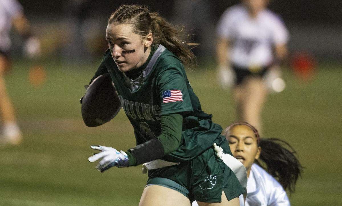 Ponderosa Bruins receiver Rowan Thomas (4) picks up yards before being tackled by the Woodcreek Timberwolves' Ryan Nair during the 2024 Sac-Joaquin Section Division II championship girls flag football game.