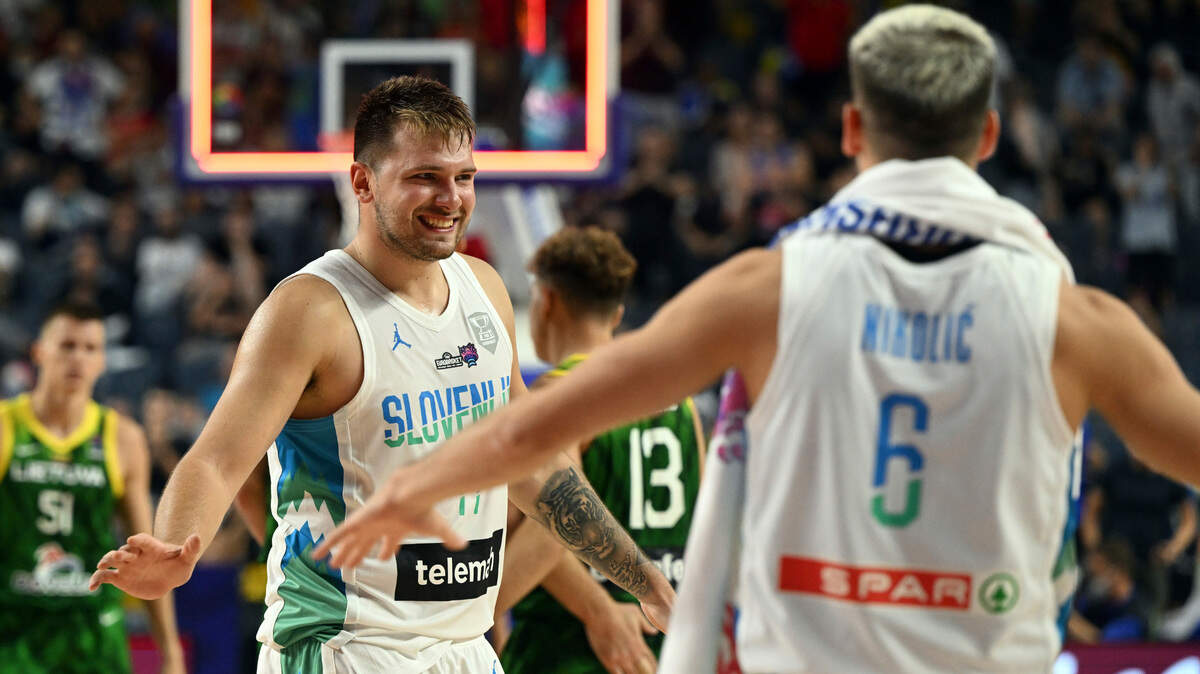 Slovenia’s Luka Doncic, left, celebrates his team’s victory during the Eurobasket group B basketball match Slovenia against Lithuania, in Cologne, Germany, Thursday, Sept. 1, 2022. (Federico Gambarini/dpa via AP)