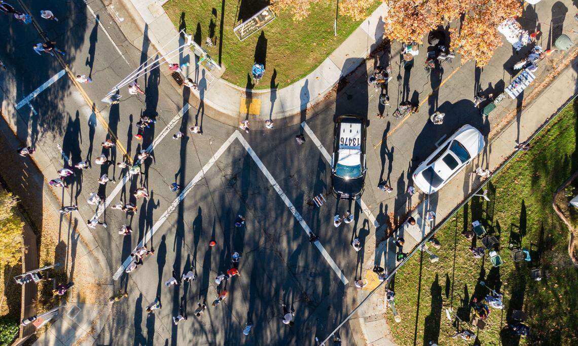 Participants of the Run to Feed the Hungry pass the corner of 53rd and H streets on Thursday, Nov. 28, 2024 in Sacramento as Los Juarez Mariachi plays Mexican music. 
