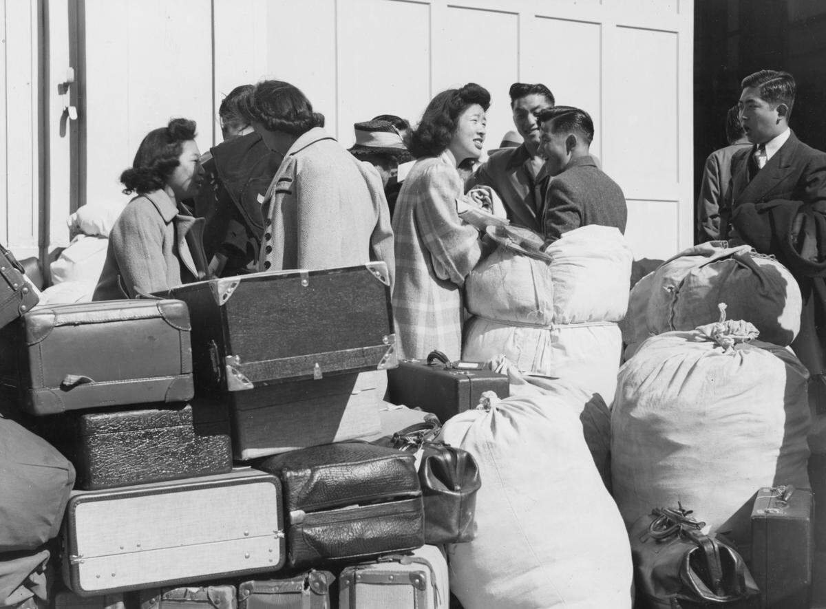 Young residents of Japanese ancestry await a bus at the Wartime Civil Control Administration station in San Francisco in 1942. They were part of the first group to be sent to incarceration centers for the duration of World War II.