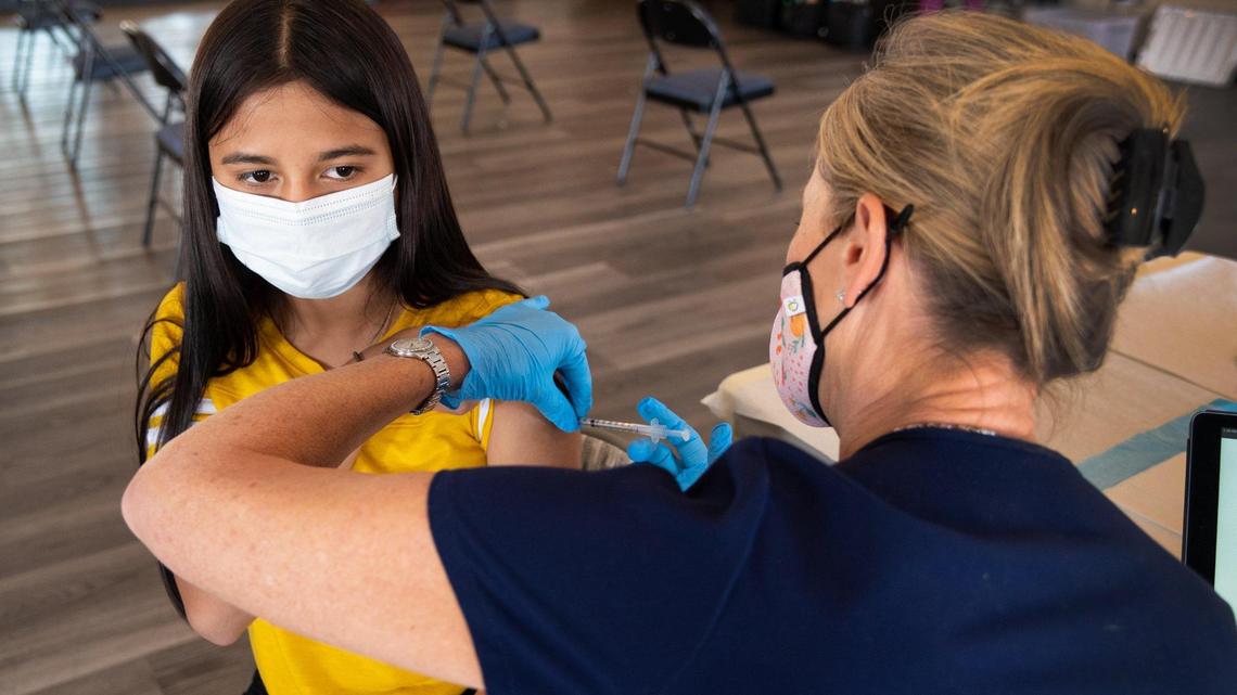 Hilary Caceres, 15, receives her second Pfizer vaccine shot Thursday, Sept. 30, 2021, from Sacramento Medical Reserve Corps nurse Cindy Ferguson during a clinic at Asian Resources Inc. on Elder Creek Road in Sacramento.