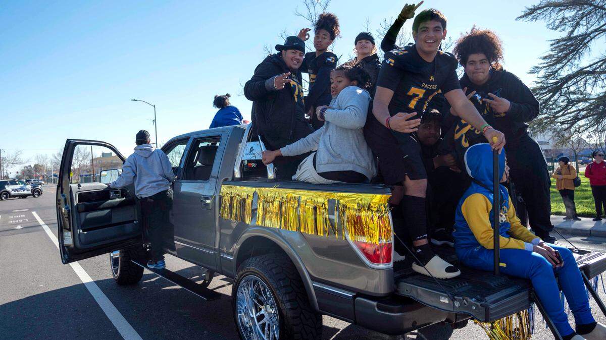 Grant High School football players, including Lucio Dominguez, center, celebrate their state championship win during a parade Saturday, Jan. 21, 2023, in Del Paso Heights.