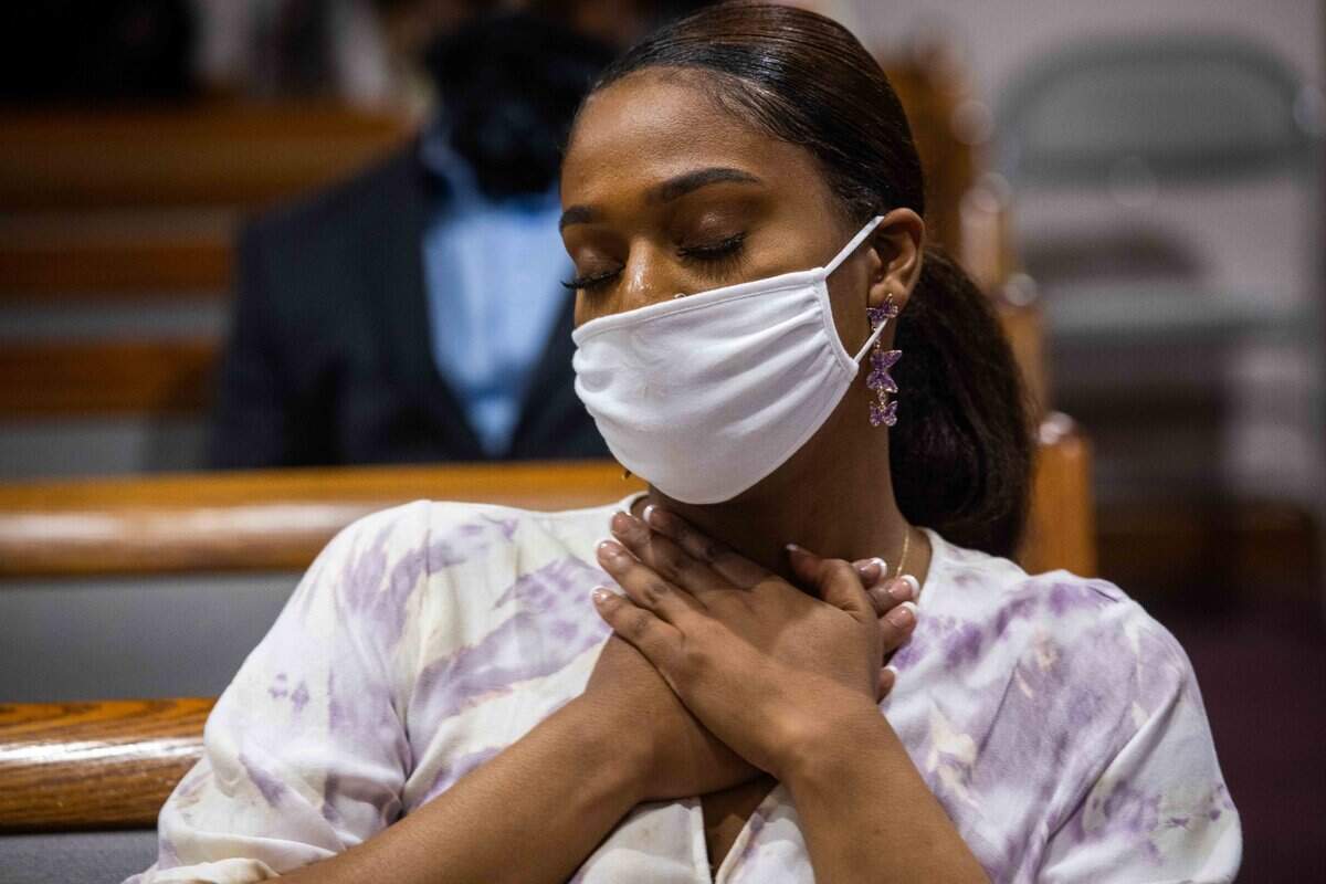 Jordan Robinson, 24, holds her hands to her heart during prayer.