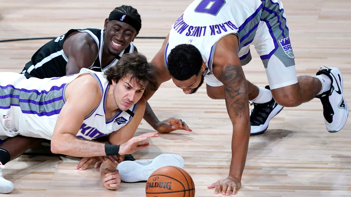 Brooklyn Nets’ Caris LeVert, back, reacts while competing for a loose ball against Sacramento Kings’ Nemanja Bjelica, front, and Cory Joseph during the second half of an NBA basketball game Friday, Aug. 7, 2020 in Lake Buena Vista, Fla. (AP Photo/Ashley Landis, Pool)